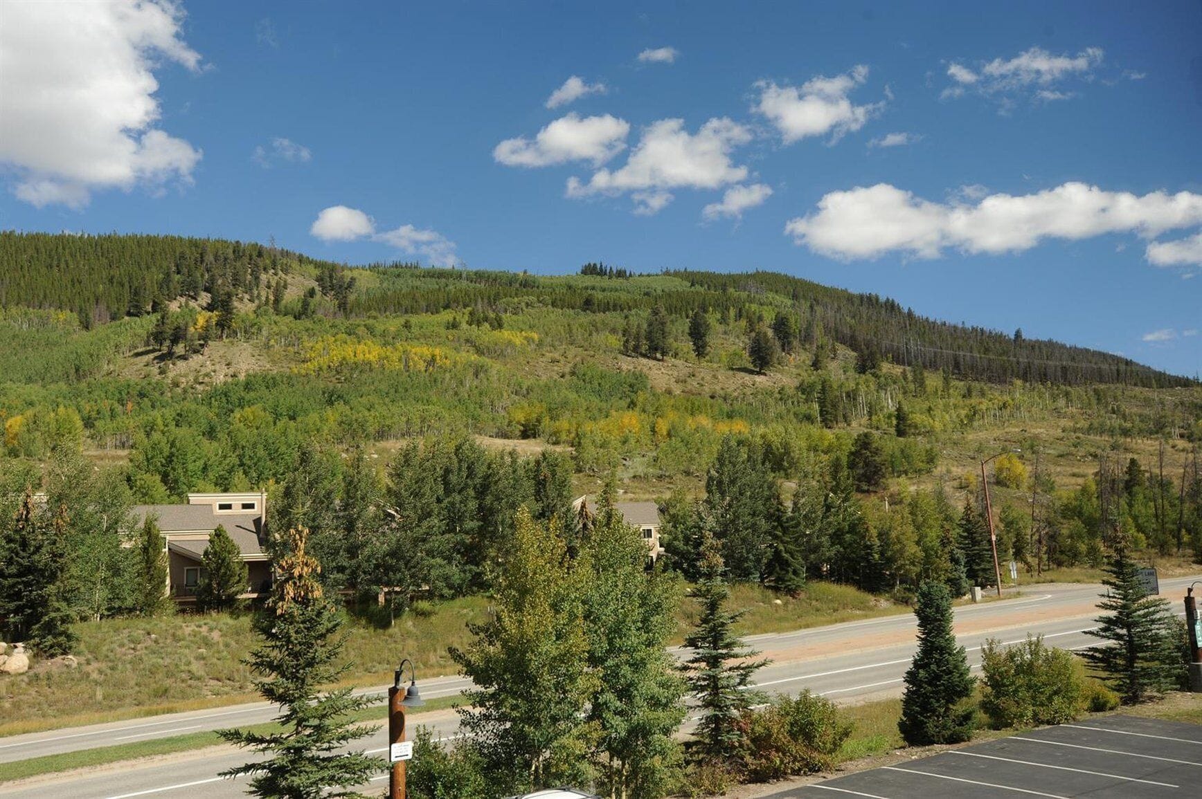 Une route avec un parking et des maisons situées sur une colline.