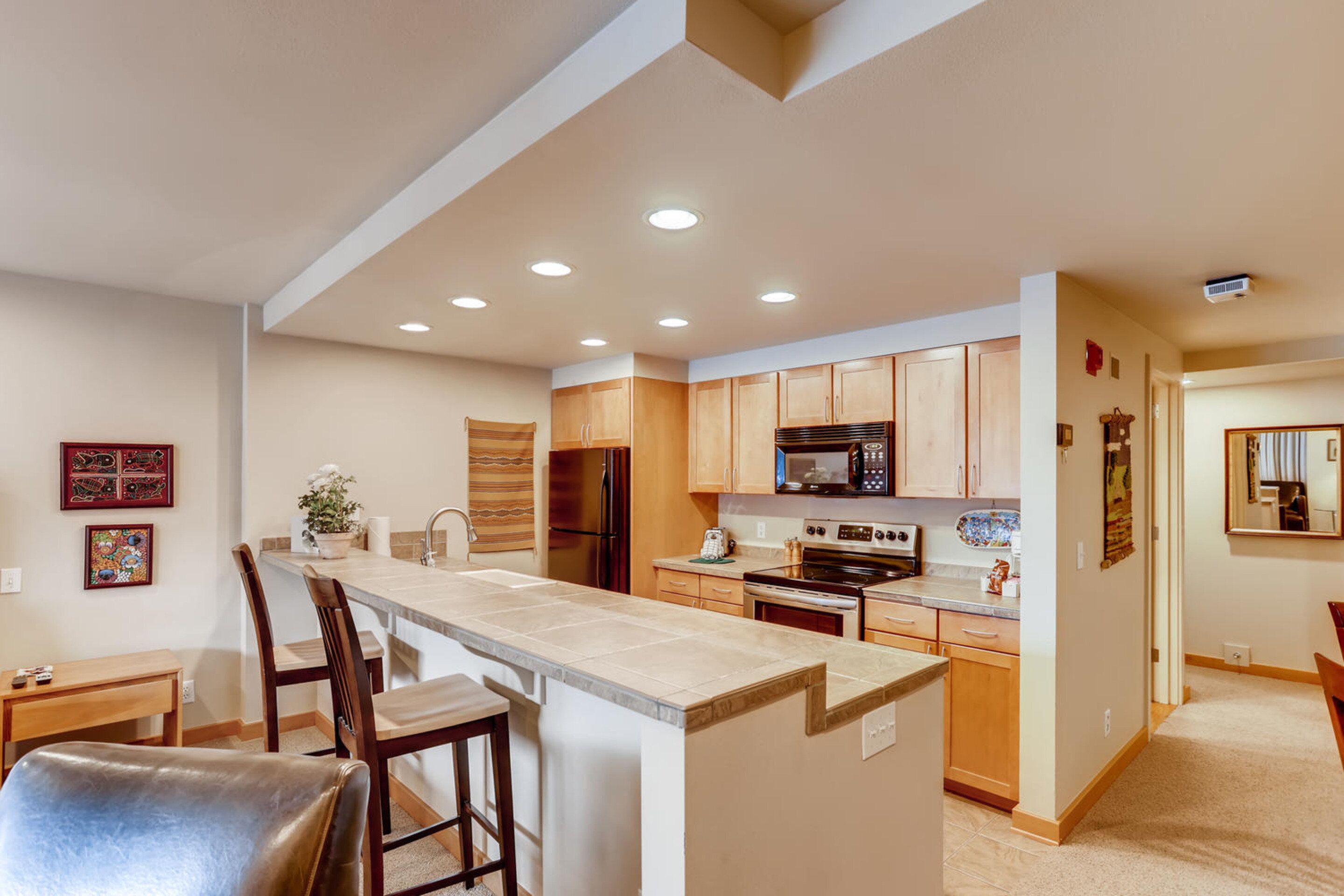 Una cocina moderna con una isla central, armarios de madera y electrodomésticos integrados.