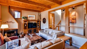 A cozy living room with a fireplace, wooden ceiling, and a comfortable seating area. - Aspen Ridge Condominiums by Vail Resorts (Keystone)