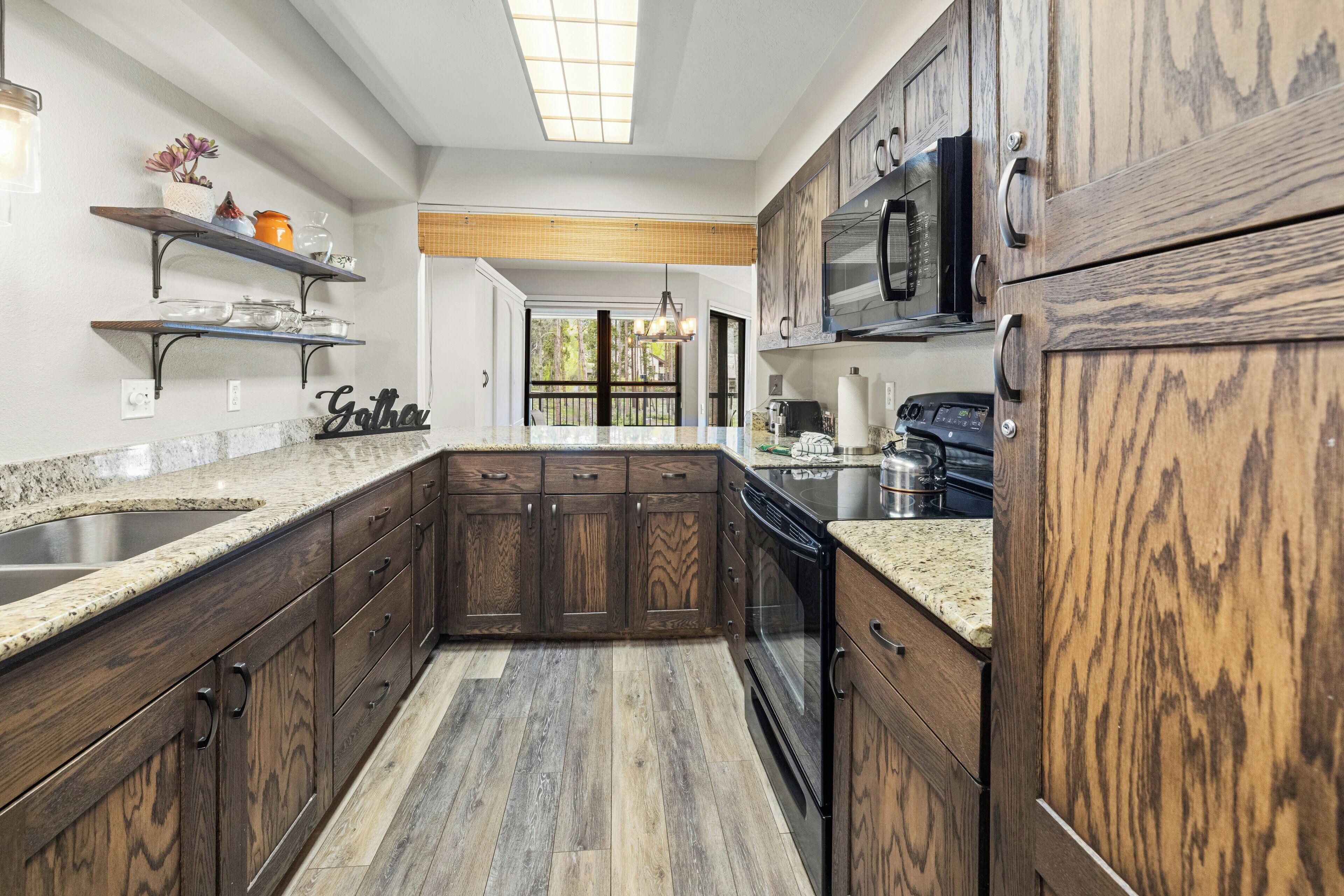 A kitchen with wooden cabinets, granite countertops, and a built-in oven.