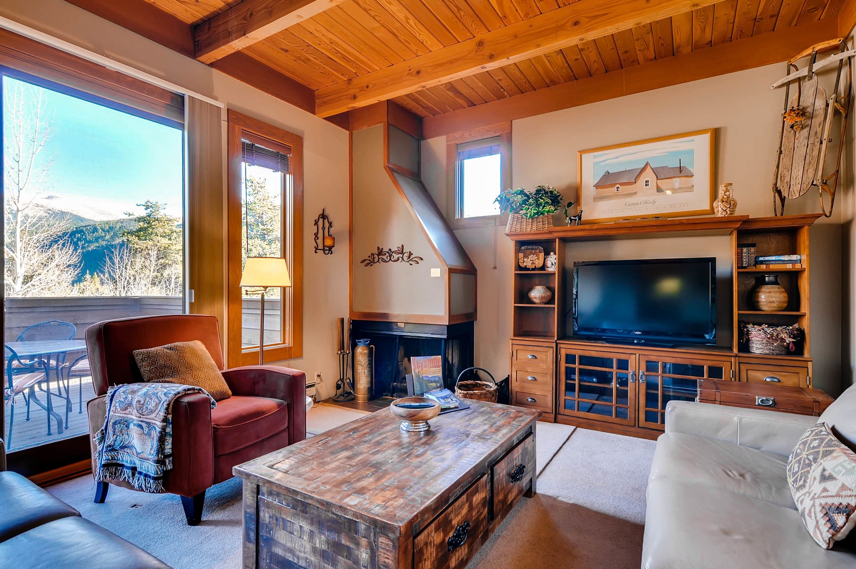 A cozy living room with a fireplace, a large TV, and a comfortable seating area.