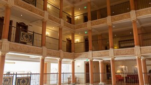 A multi-level hotel lobby with ornate columns, a checkered floor, and a ceiling mural. - Europa-Park Erlebnis-Resort, Hotel Colosseo (Rust)