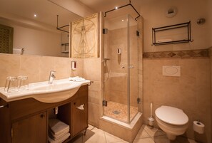 A modern bathroom with a glass-enclosed shower, a sink with a vanity, and a toilet. - Europa-Park Erlebnis-Resort, Hotel Colosseo (Rust)