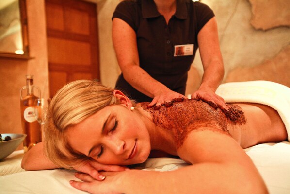 A person receiving a massage in a room with a wooden door and a bottle of oil on the side. - Europa-Park Erlebnis-Resort, Hotel Colosseo (Rust)