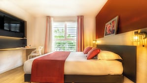 A modern hotel room with a large bed, a flat-screen TV, a bedside table, and a window with curtains. - City Résidence Bordeaux Centre (Bordeaux)