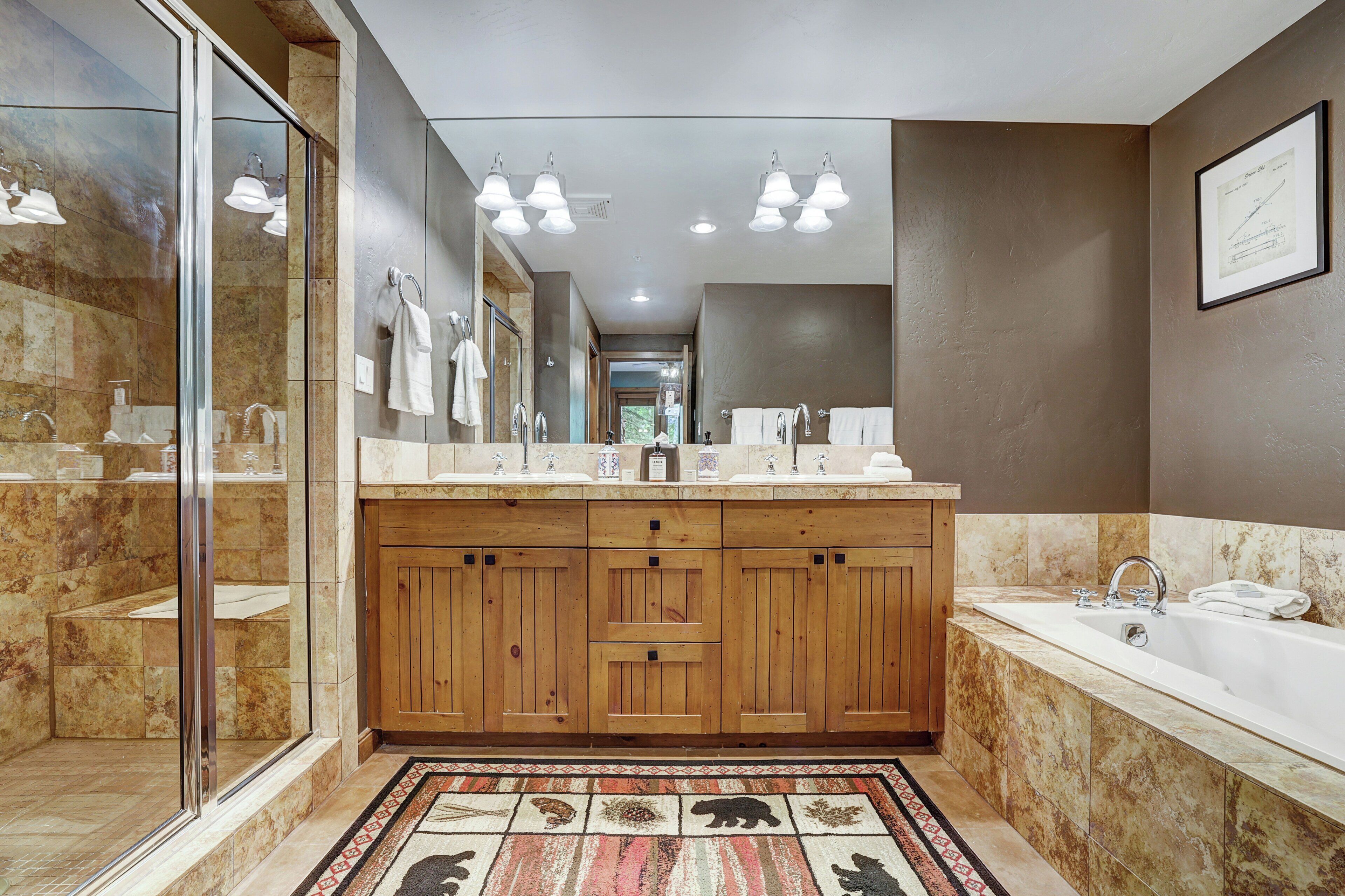 A modern bathroom with a large mirror, wooden vanity, and a bathtub.