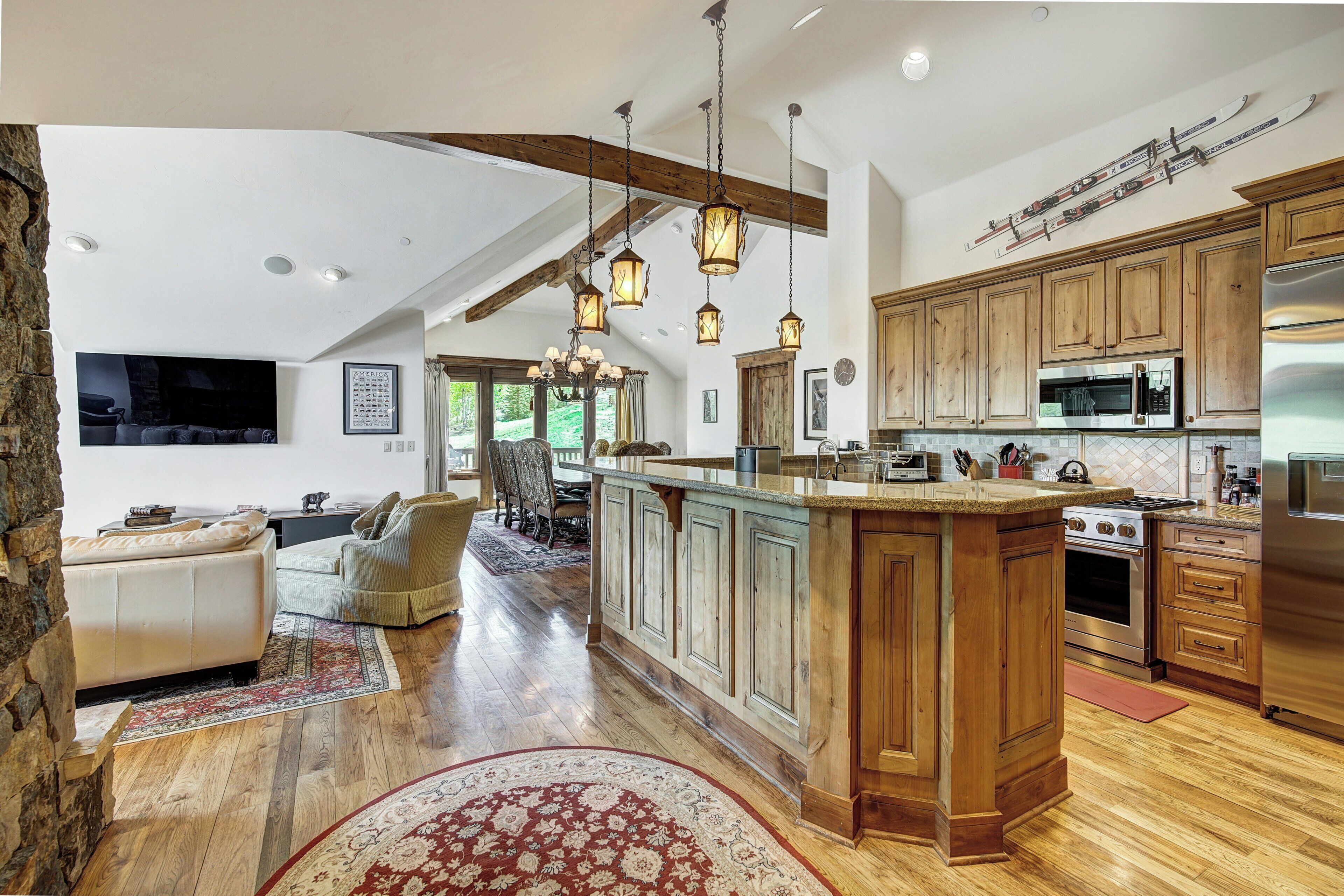 A spacious kitchen with wooden cabinets, a large island, and modern appliances.