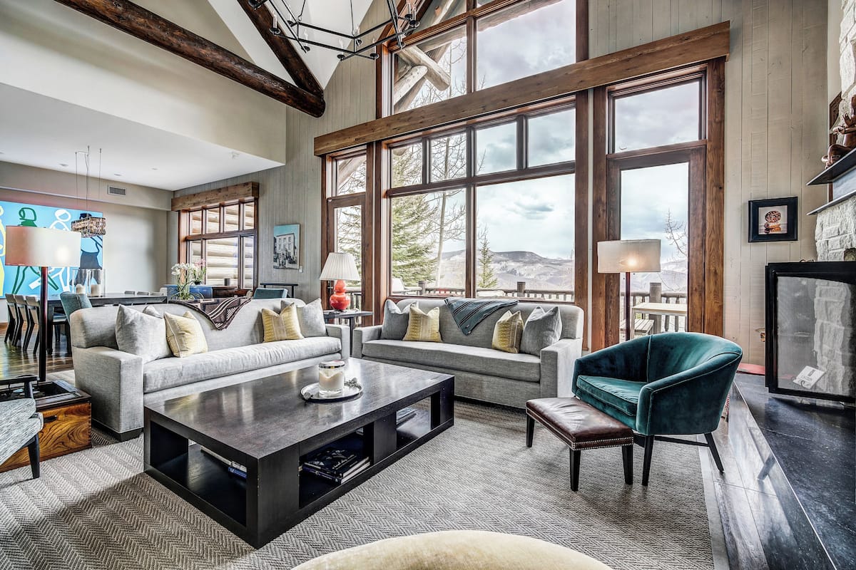 A spacious living room with large windows, a fireplace, and a cozy seating area.