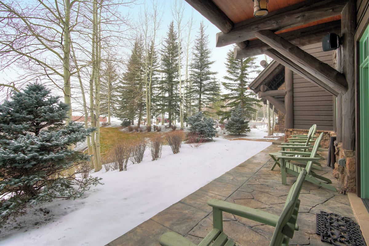 A wooden building with a stone-paved walkway and snow-covered ground.