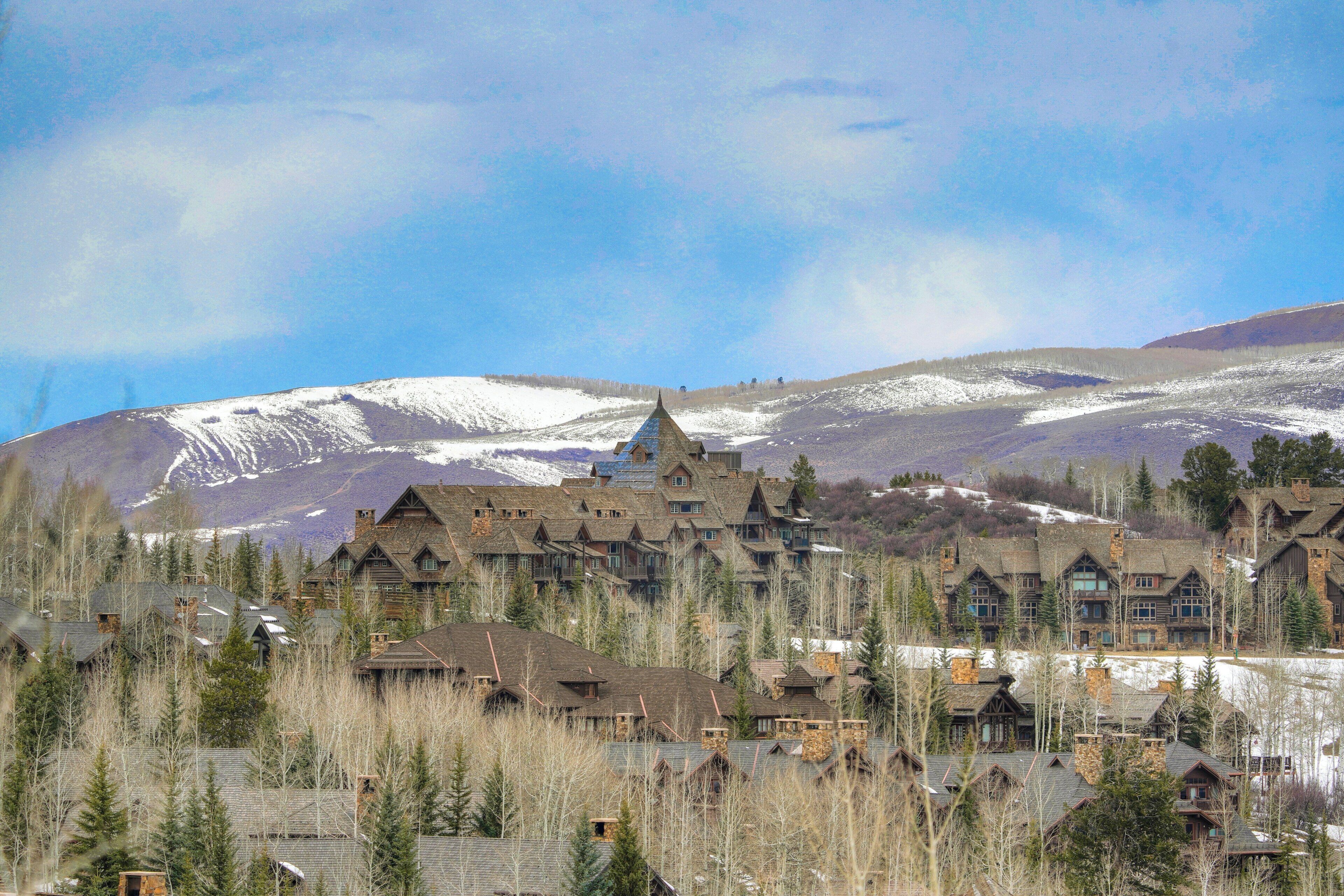 A cluster of log cabin-style buildings with a mountain backdrop.