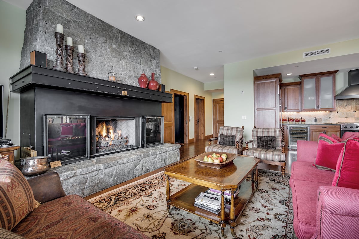 A cozy living room with a fireplace, a coffee table, and comfortable seating.
