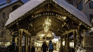 La entrada del centro turístico Beaver Creek, con un corredor cubierto y árboles cubiertos de nieve.