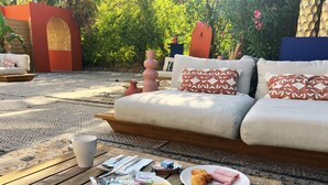 A wooden table with breakfast items, a white cup, and a plate with croissants and ham.