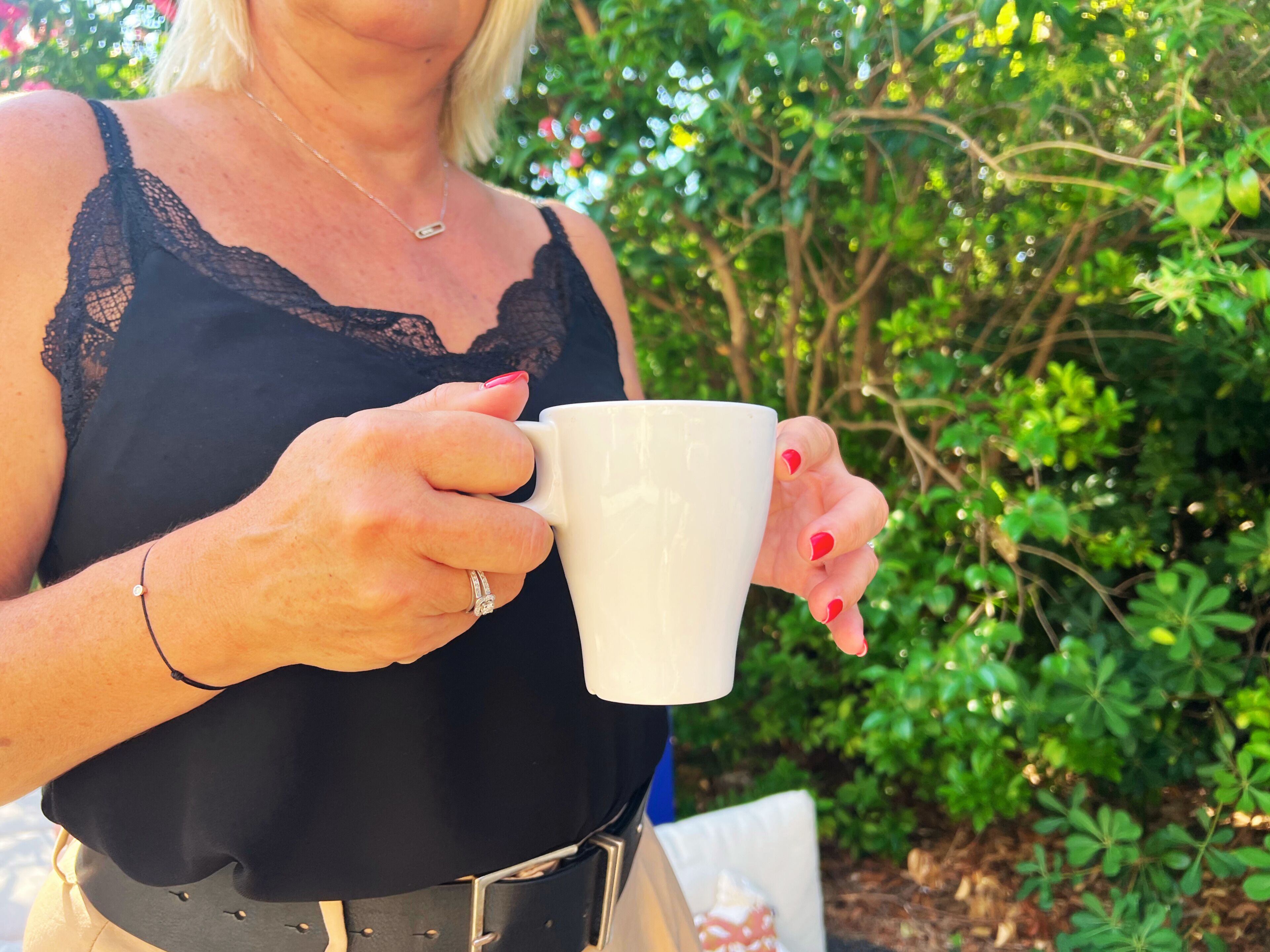 Una persona sosteniendo una taza blanca.