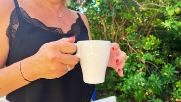 Una persona sosteniendo una taza blanca.
