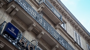 Fachada de edifício com varandas ornamentadas e um letreiro do Tim Hotel.