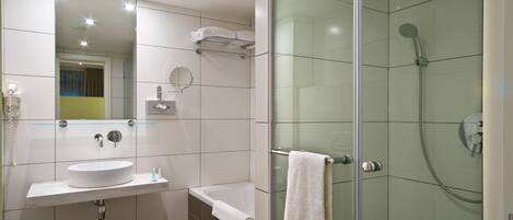 A modern bathroom with a glass-enclosed shower, a white sink, and a bathtub.