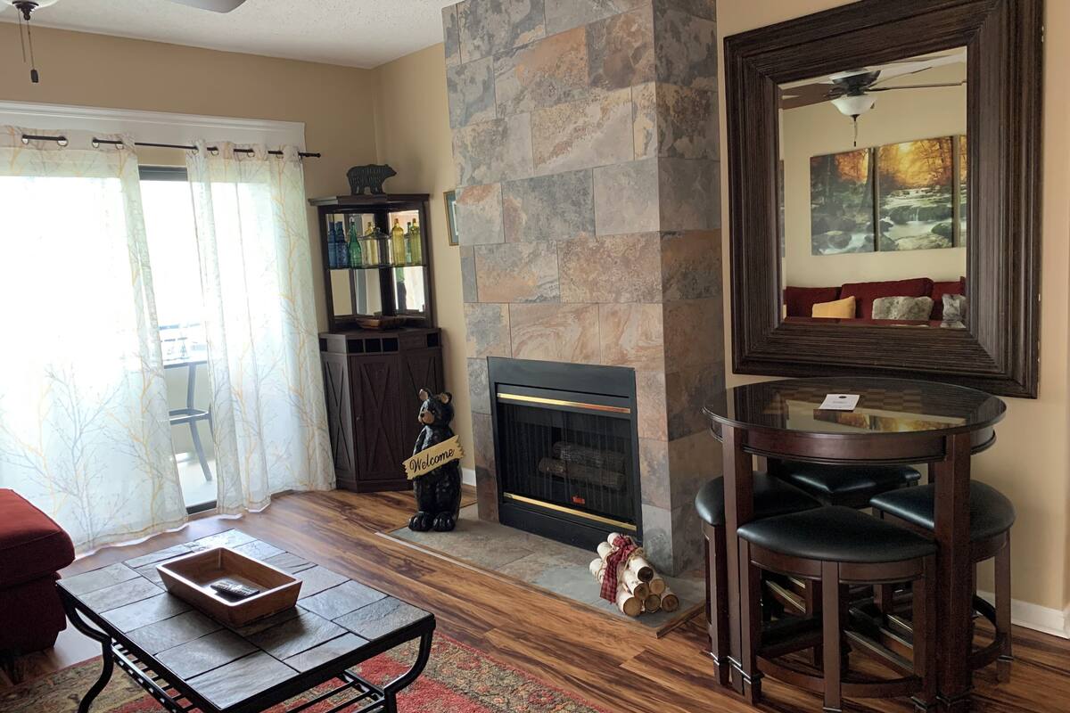 A living room with a fireplace, a coffee table, a sofa, and a large mirror.
