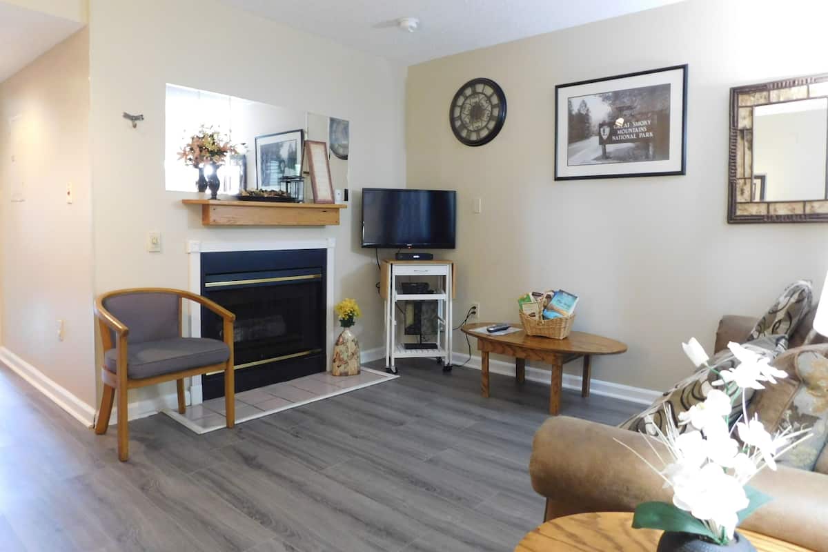 A living room with a fireplace, a television, a sofa, and a coffee table.