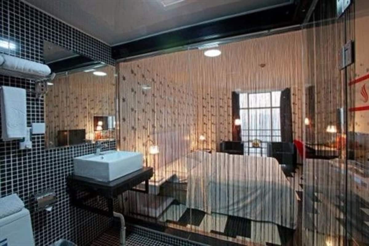 A modern bathroom with a large mirror, a sink, and a shower area.