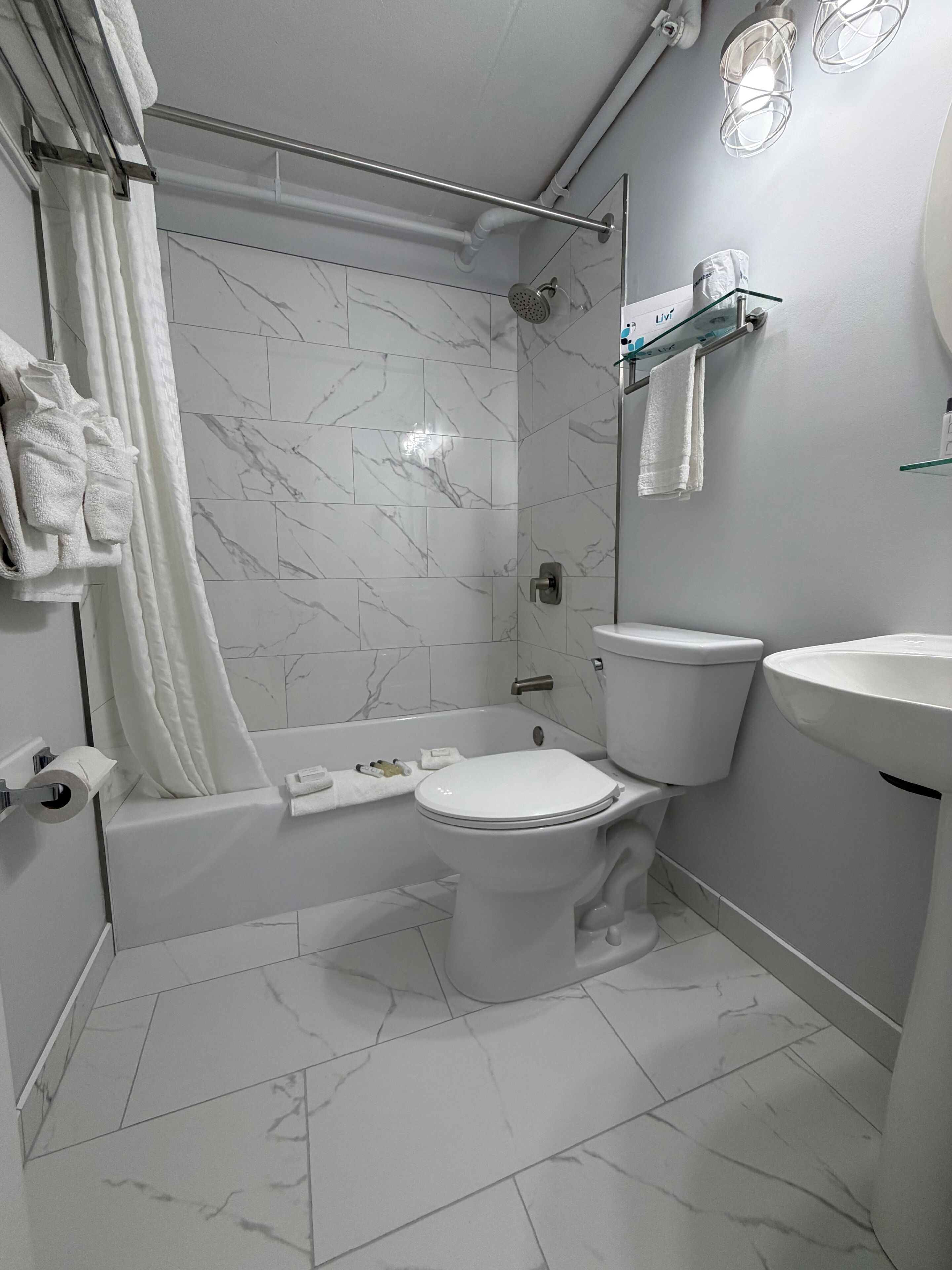 A bathroom with a toilet, bathtub, and shower.
