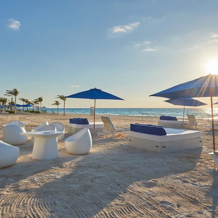 On the beach, white sand, beach cabanas, sun loungers