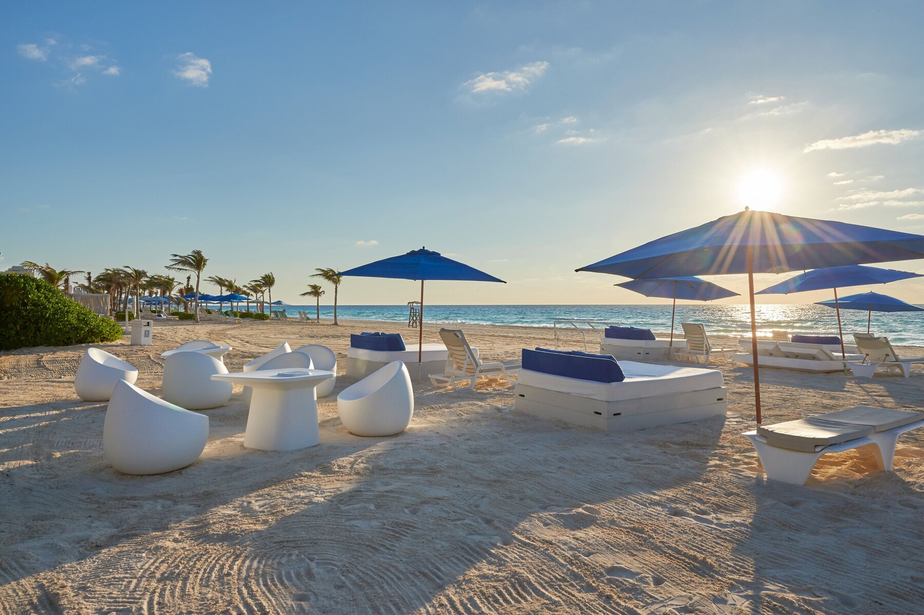 On the beach, white sand, beach cabanas, sun loungers