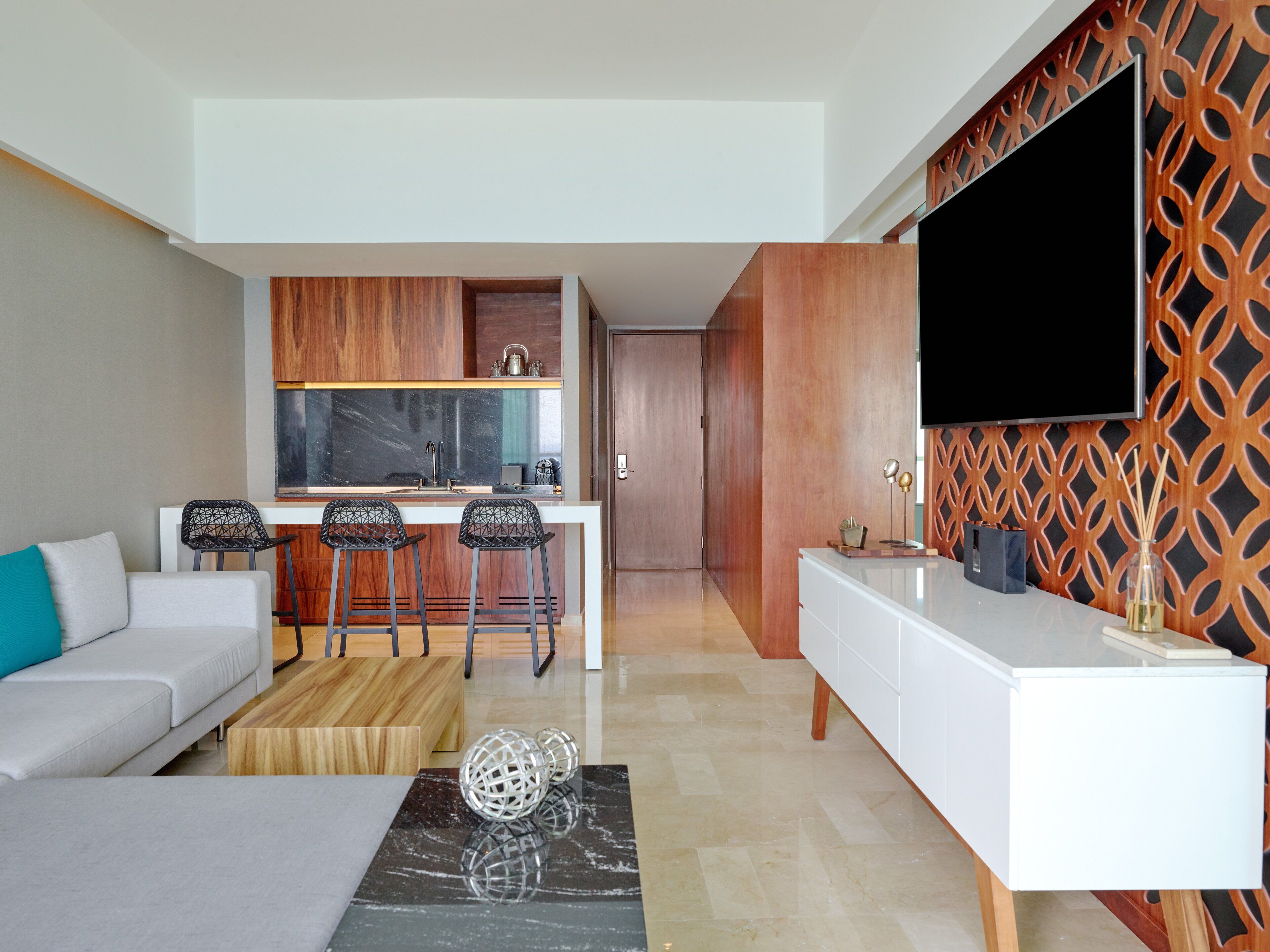 Una sala de estar moderna con un sofá, una mesa de centro y una zona de cocina con barra.