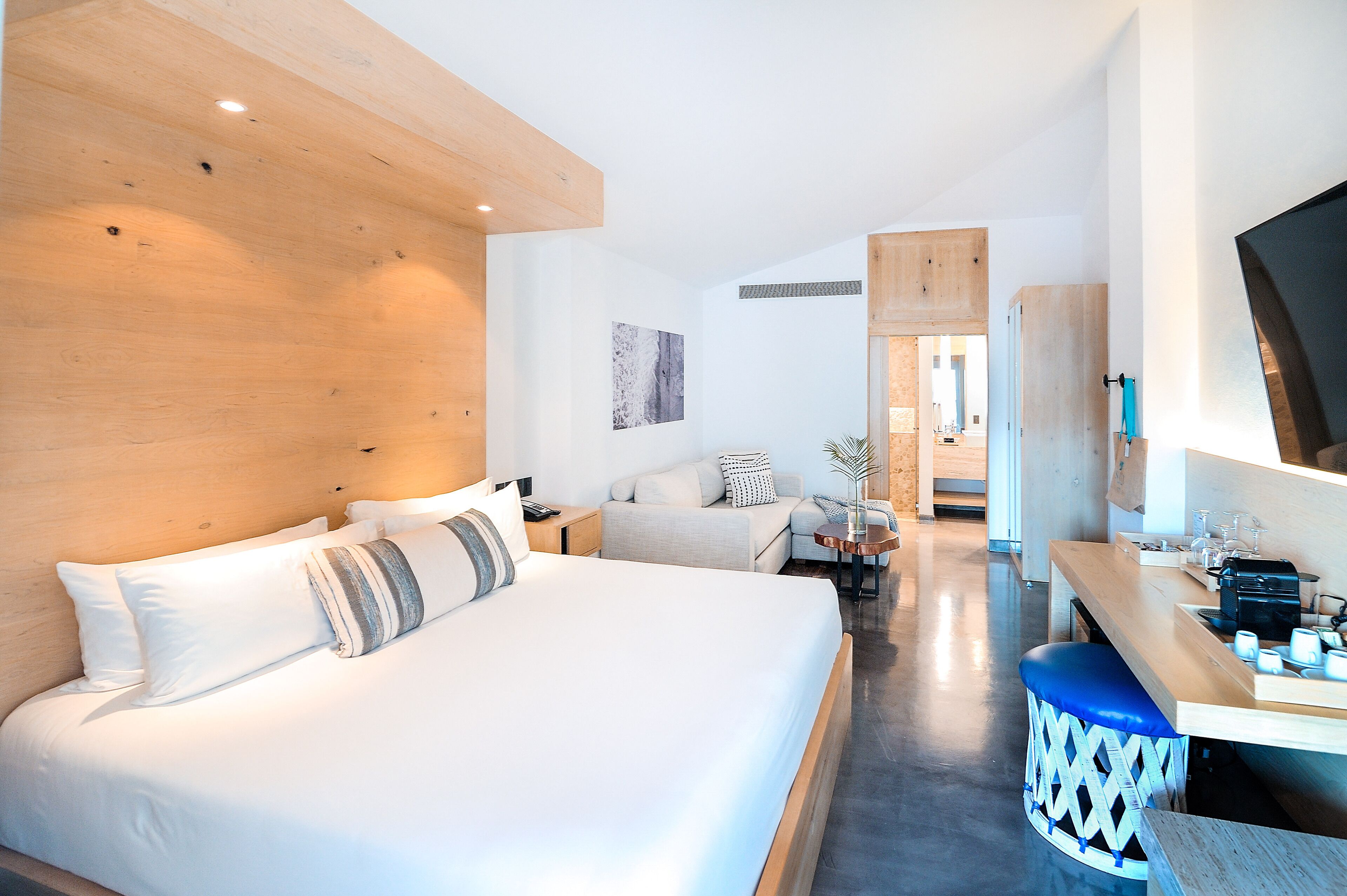 Een moderne hotelkamer met een groot bed, een bank, een eethoek en een televisie.