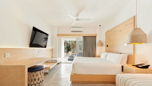 Une chambre d’hôtel moderne équipée d’un grand lit, d’un bureau, d’une télévision et d’un ventilateur de plafond.