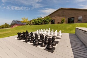 A chessboard set up on a wooden deck with a house in the background. - Holiday Hills Resort at Branson (Branson)