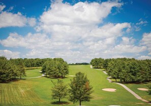 A golf course with a clear sky, trees, and sand bunkers. - Holiday Hills Resort at Branson (Branson)