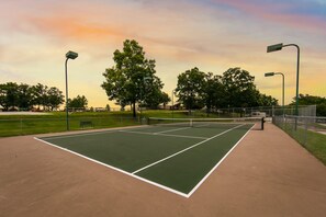 A tennis court with a net, surrounded by trees and street lamps. - Holiday Hills Resort at Branson (Branson)