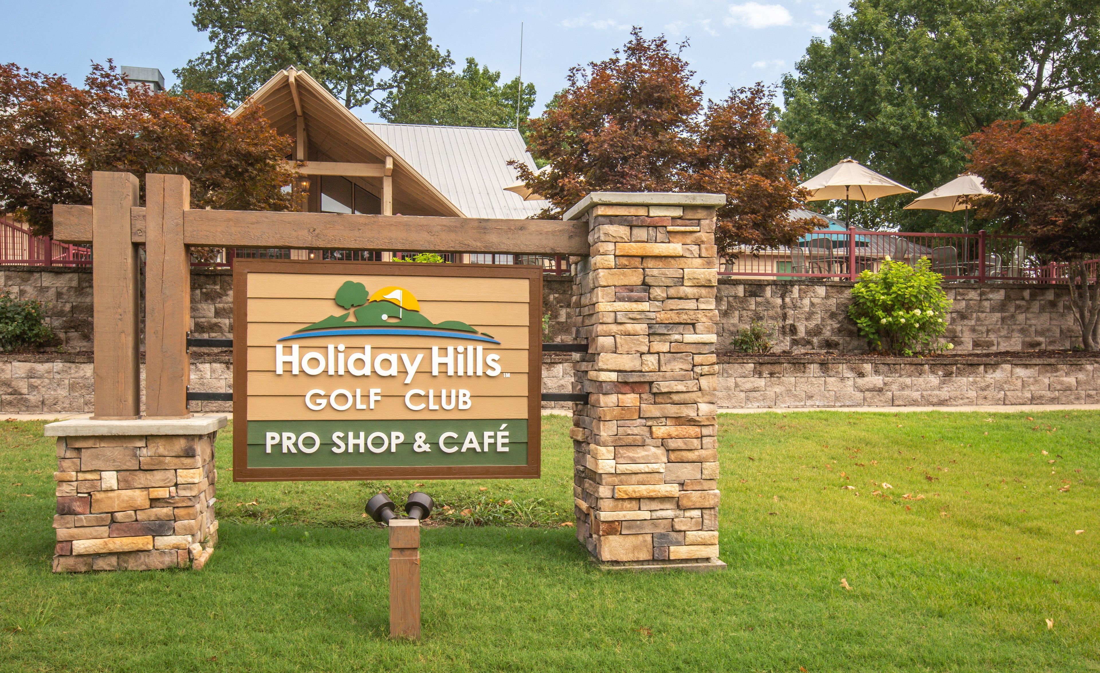 Placa do Holiday Hills Golf Club, com loja de golfe profissional e café.