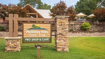 Placa do Holiday Hills Golf Club, com loja de golfe profissional e café.