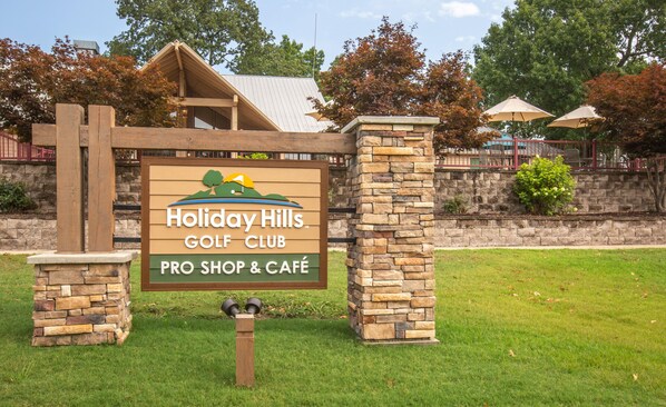 Señal del Holiday Hills Golf Club con tienda de profesionales y cafetería.