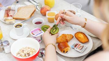 A breakfast setting with toast, fruit, a croissant, and a cup of coffee.