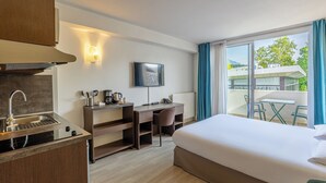 A hotel room with a bed, desk, chair, and a TV. - Les Loges du Park – résidence hôtelière (Aix-les-Bains)