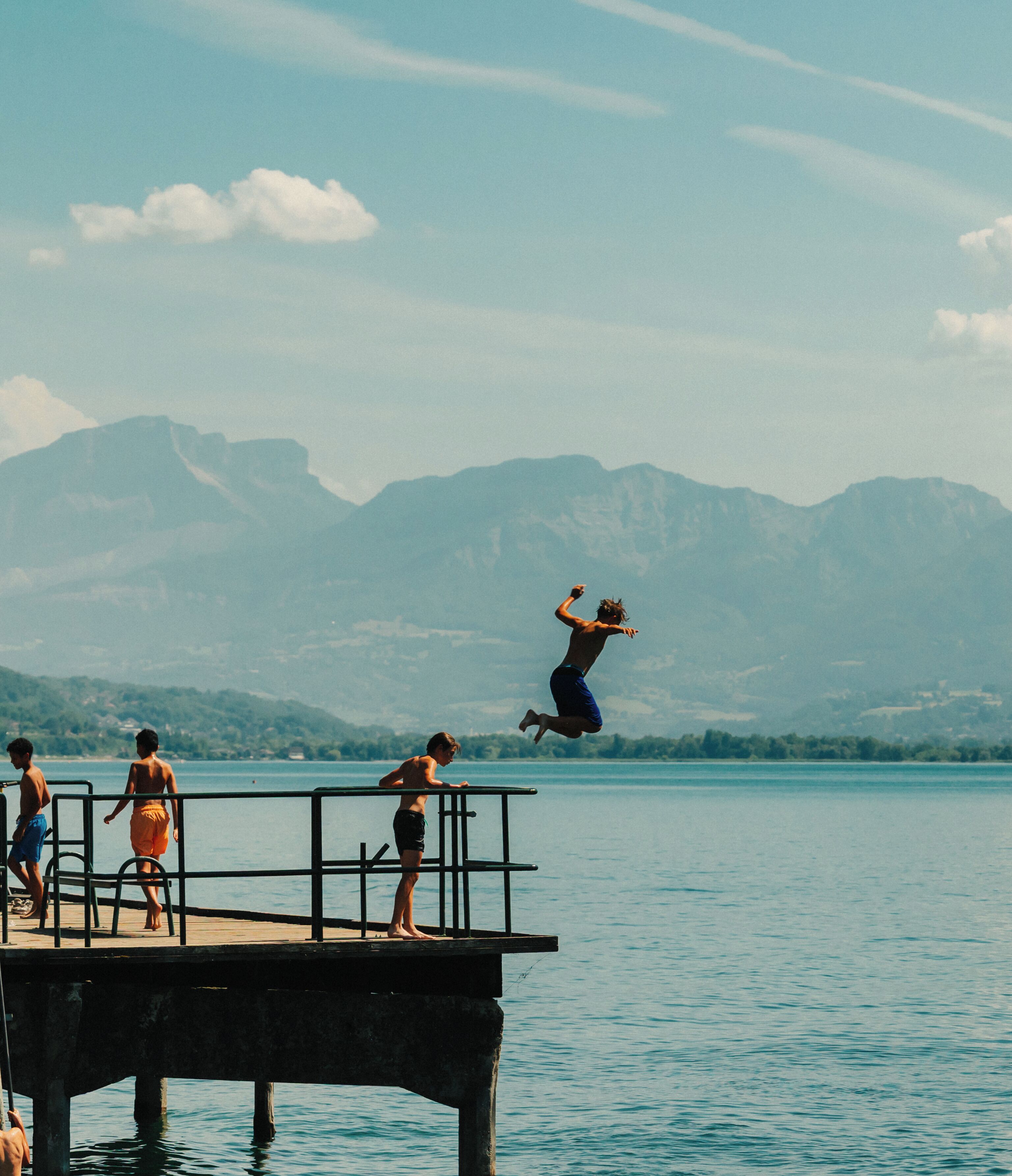A pier extending into a body of water with mountains in the background.