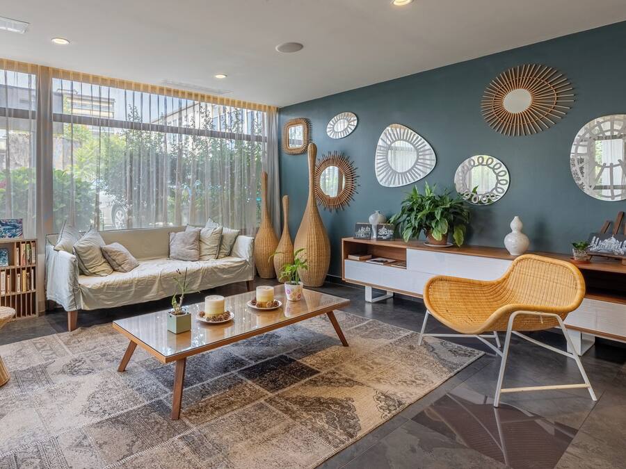 A modern living room with a sofa, coffee table, and decorative mirrors.
