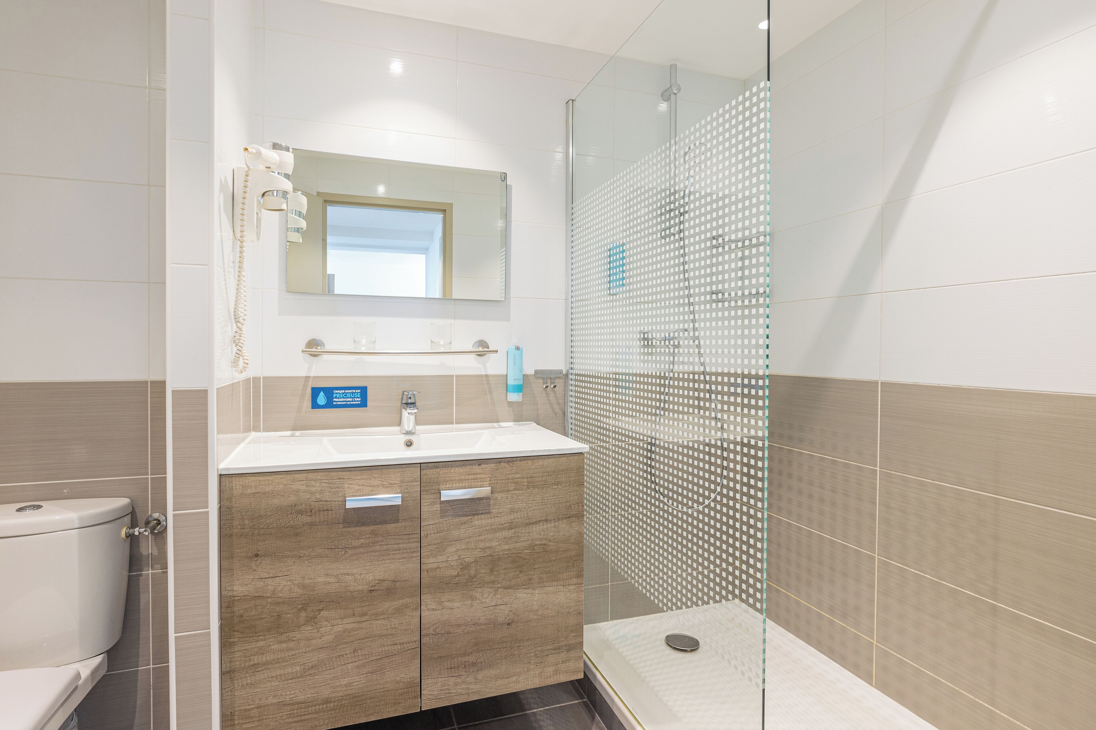 Une salle de bain moderne avec une douche à parois de verre, un meuble-lavabo en bois et des toilettes.