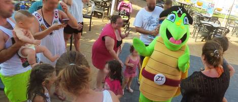 A group of people gathered around a mascot at an outdoor event.