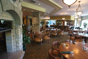 A restaurant with stone walls, wooden tables, and chairs. - StoneBridge Resort (Branson West)