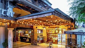 Una cafetería con un letrero que dice "Café - Chocolate" y una exhibición de diversos productos de café.