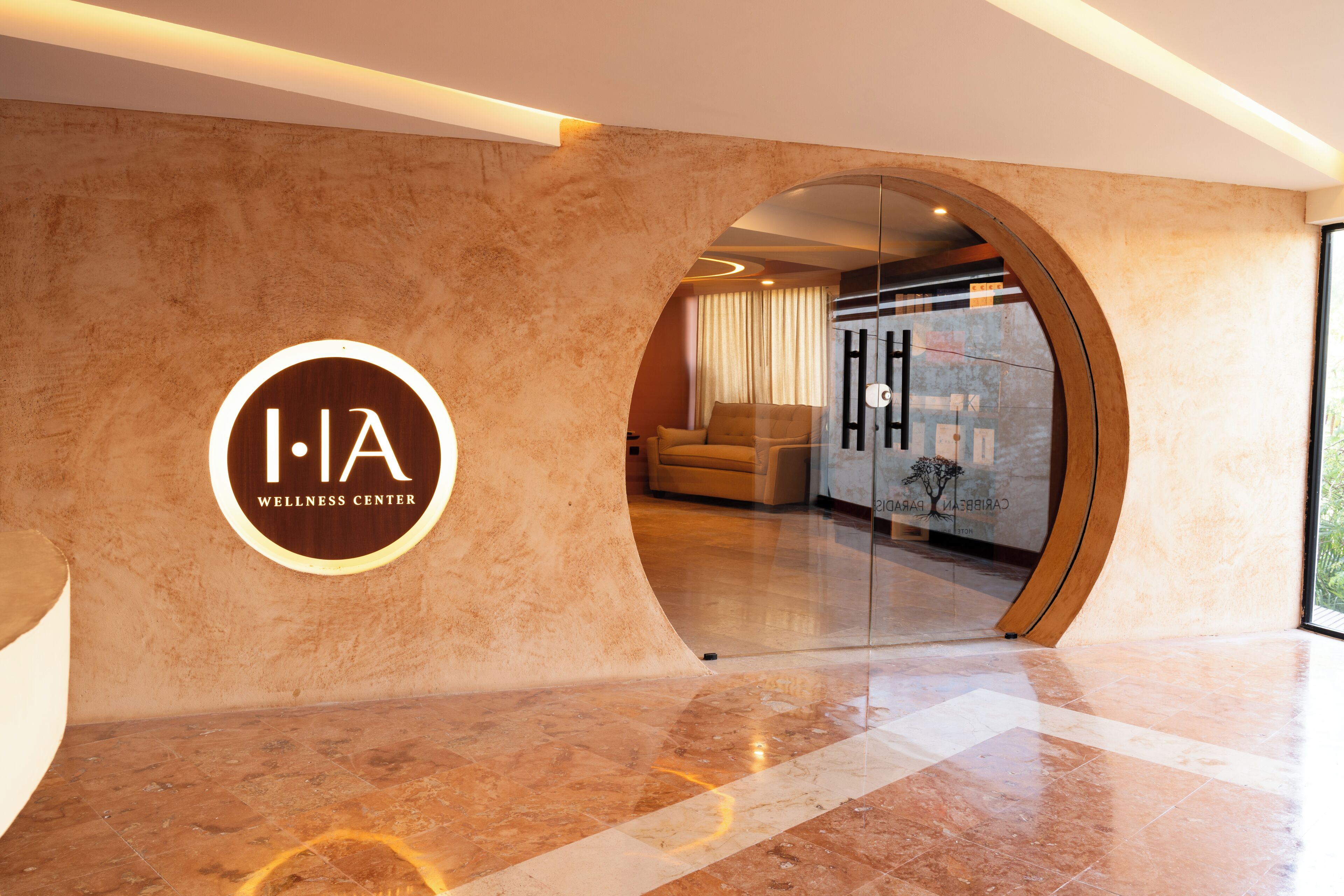 A wellness center with a circular logo, a reception area, and a view of a room with a sofa and curtains.