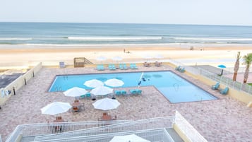 Een buitenzwembad, parasols voor strand/zwembad