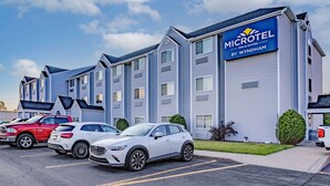 A Microtel Inn & Suites by Wyndham building with a parking lot and several cars parked in front.
