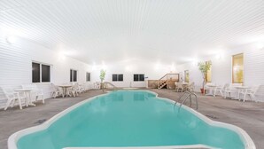 Ein hallenbad mit Fliesenboden, umgeben von weißen Wänden und Möbeln.