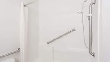 A modern bathroom with a glass shower enclosure, a grab bar, and a white toilet.