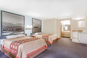 Habitación de hotel con dos camas, un baño y vistas a las montañas.